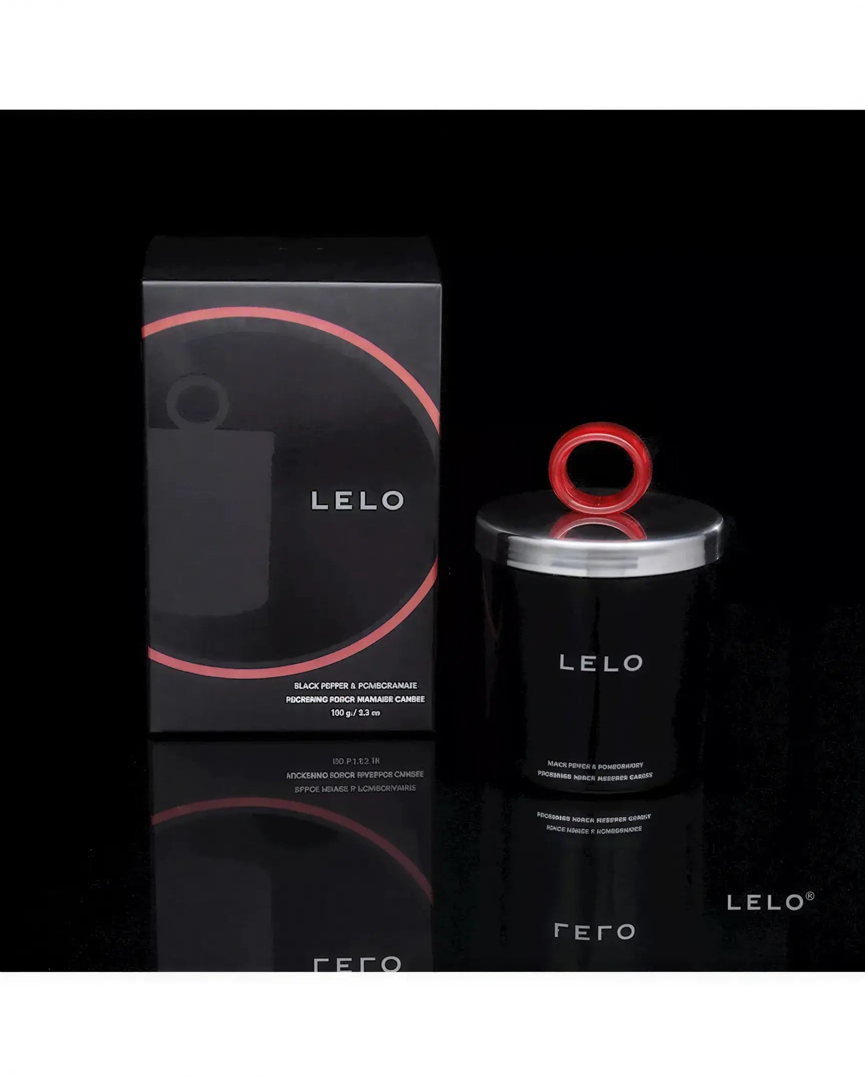 Lelo massage candle in a black container with a red lid, displayed beside its black box packaging.