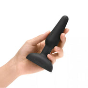 B-Vibe Trio Plug held in a hand, featuring a sleek black silicone design and tapered shape for easy insertion.