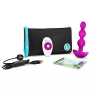 B-Vibe Triplet anal beads in purple with remote control, USB charger, and storage pouch displayed on a white background.