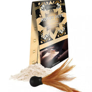 Kama Sutra Honey Dust kissable body powder in Vanilla Crème with a feather applicator and powder spilling from the box.