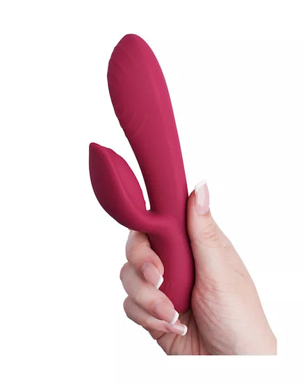 Rocks Off Every Girl vibrator in a deep pink color, held in a hand, featuring a curved design and textured surface in a hand.