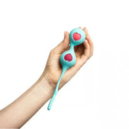 Clio Kegel balls in teal with pink heart designs, held in a hand, featuring a connecting silicone string.