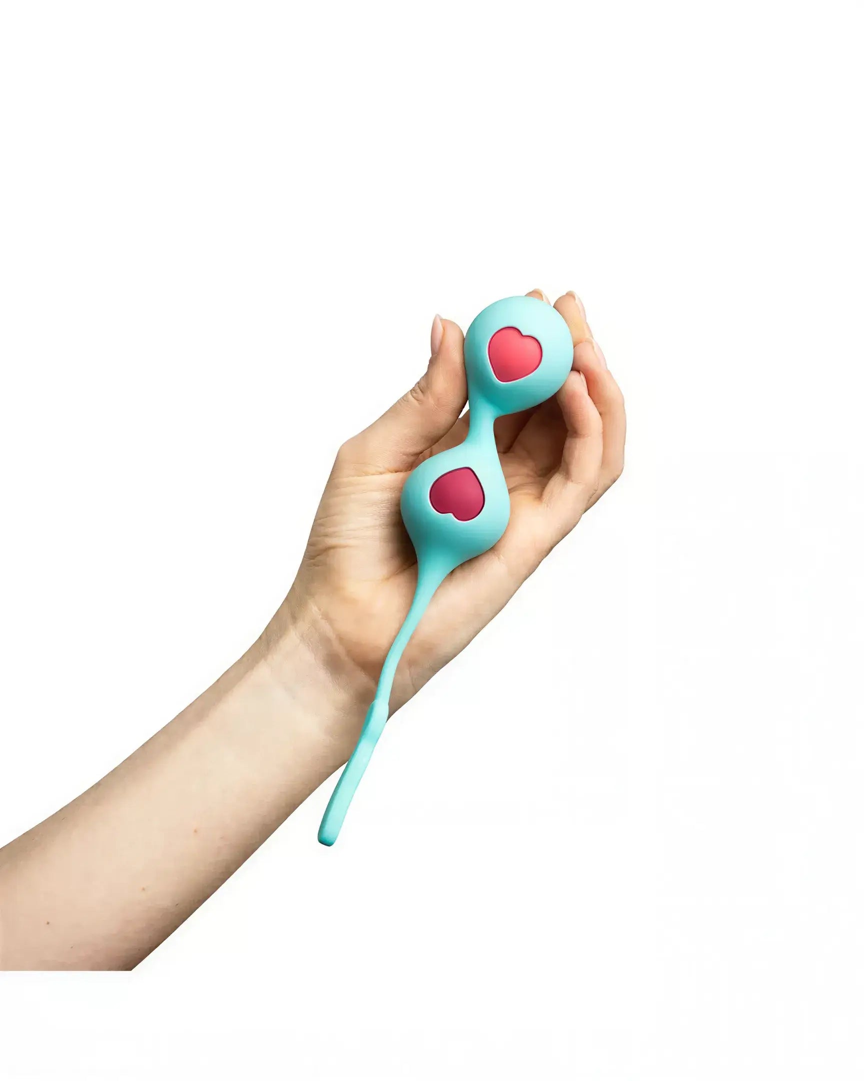 Clio Kegel balls in teal with pink heart designs, held in a hand, featuring a connecting silicone string.