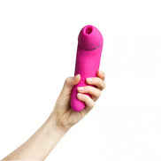 Pink Electra sucking vibrator held in a hand, featuring a rounded tip and smooth silicone texture.