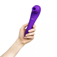 Purple Calla sucking vibrator held in a hand, featuring a curved design and a suction tip.