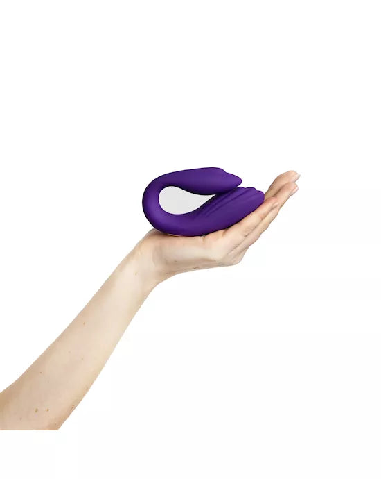 Purple remote-controlled couples vibrator with a sleek design and a white control panel in a hand.