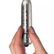Rocks Off Frosted Fleurs bullet vibrator held in a hand, featuring a shiny silver finish and tapered design.