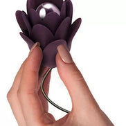 Rocks Off Zinnia vibrator held in a hand, featuring a purple flower design with a pearl-like center.