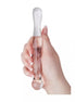 Clear glass massager held in a hand, featuring a smooth, elongated design with rounded ends.