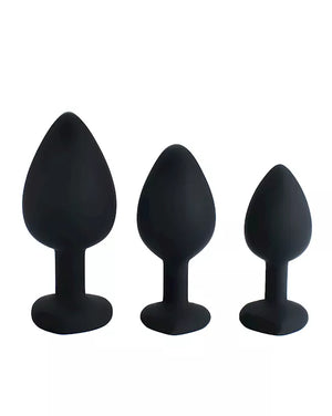 Three black silicone butt plugs of different sizes on a white background