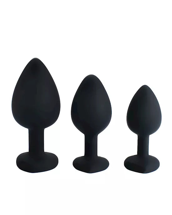 Three black silicone butt plugs of different sizes on a white background