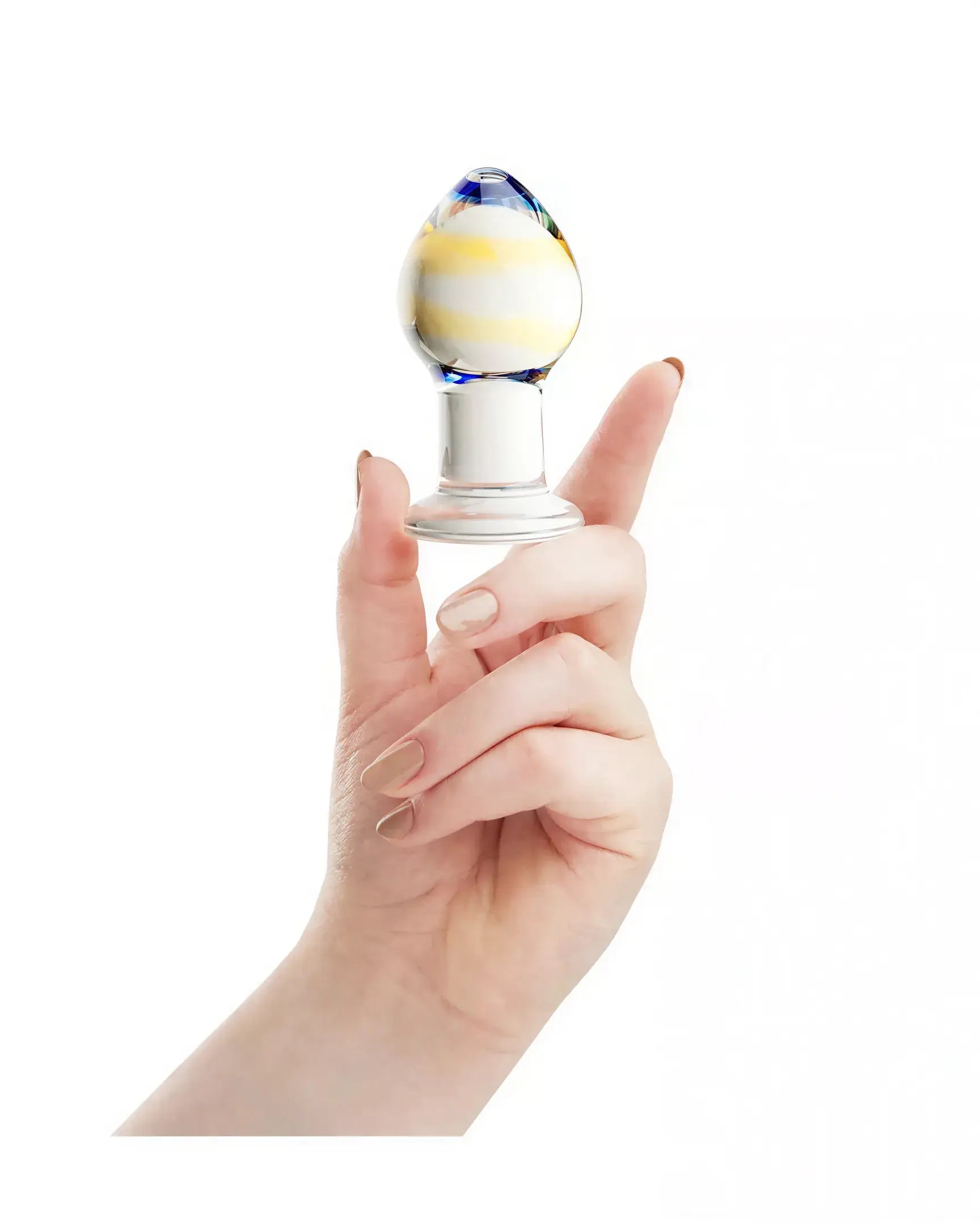 Lucent Prima glass butt plug held in a hand, featuring a colorful striped design and a clear base.