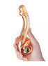 Lucent Nessa vibrating glass massager held in a hand, featuring a smooth, curved design in amber glass.