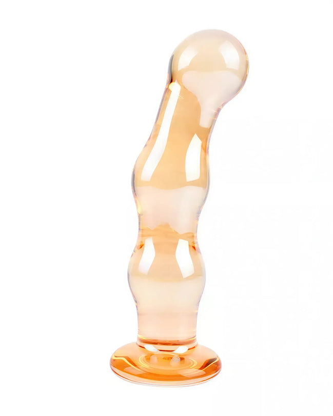 Lucent Soleil glass massager in a smooth, curved design with a translucent orange finish and a sturdy base.