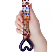 Lucent Kyle glass massager held in a hand, featuring colorful dots and a heart-shaped handle.