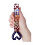 Lucent Kyle glass massager held in a hand, featuring colorful dots and a heart-shaped handle.