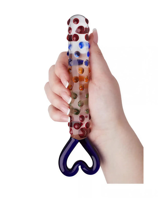 Lucent Kyle glass massager held in a hand, featuring colorful dots and a heart-shaped handle.