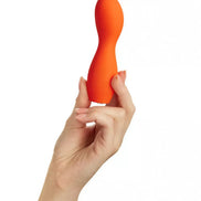 Cary bulbed vibrator held in a hand, featuring a smooth, curved design in bright orange silicone.