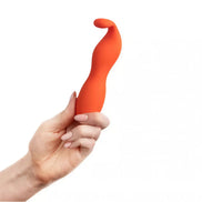 Ceba clitoral vibrator in bright orange, held in a hand, featuring a curved design for ergonomic use.