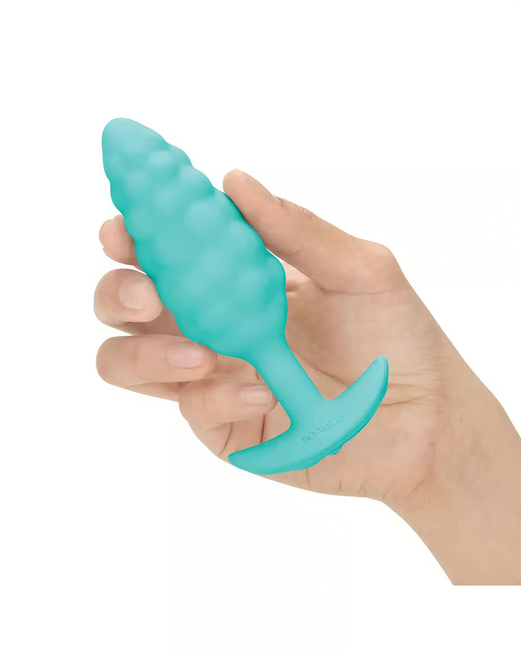 B-Vibe Bump Texture Plug in teal, held in a hand, featuring a textured surface and tapered design.