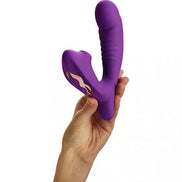 Purple silicone rabbit vibrator held in a hand, featuring a curved design and textured grip.