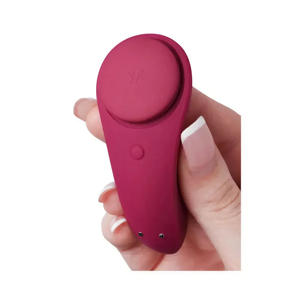 Satisfyer Sexy Secret in deep red, held in a hand, featuring a smooth silicone surface and a rounded design.