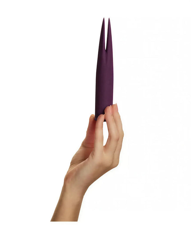 Share Satisfaction Deux in a deep purple color, held in a hand, featuring a sleek, elongated design with pointed ends.