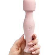 Share Satisfaction Mini Wand in soft pink, held in a hand with manicured nails, featuring a rounded head and button.