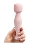 Share Satisfaction Mini Wand in soft pink, held in a hand with manicured nails, featuring a rounded head and button.