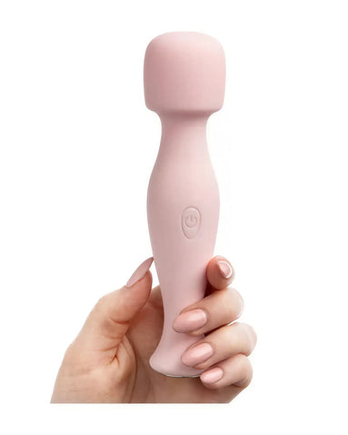 Share Satisfaction Mini Wand in soft pink, held in a hand with manicured nails, featuring a rounded head and button.
