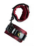 Luxury handcuffs in black and red fabric with a shiny finish, featuring a gold logo and adjustable strap.