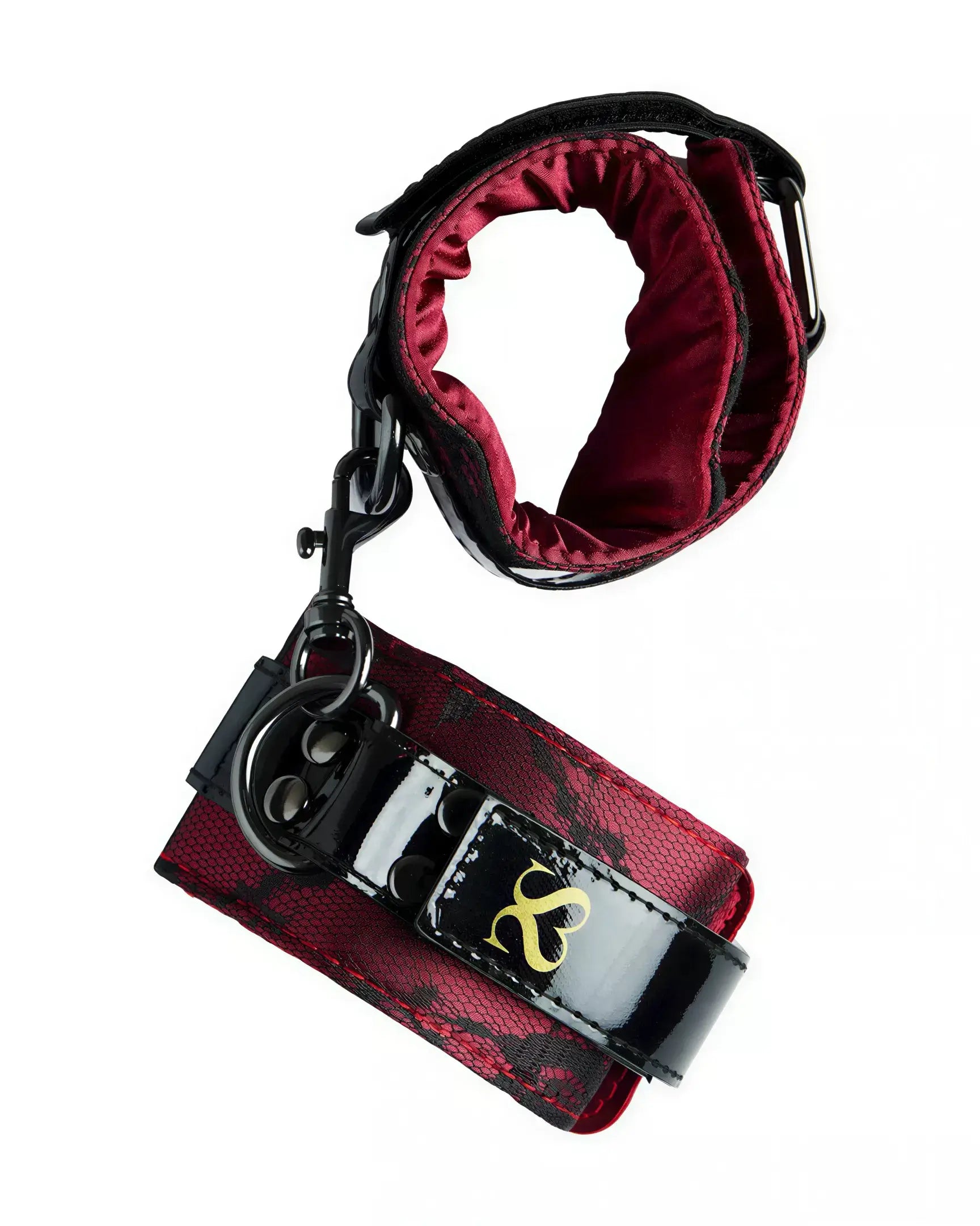 Luxury handcuffs in black and red fabric with a shiny finish, featuring a gold logo and adjustable strap.