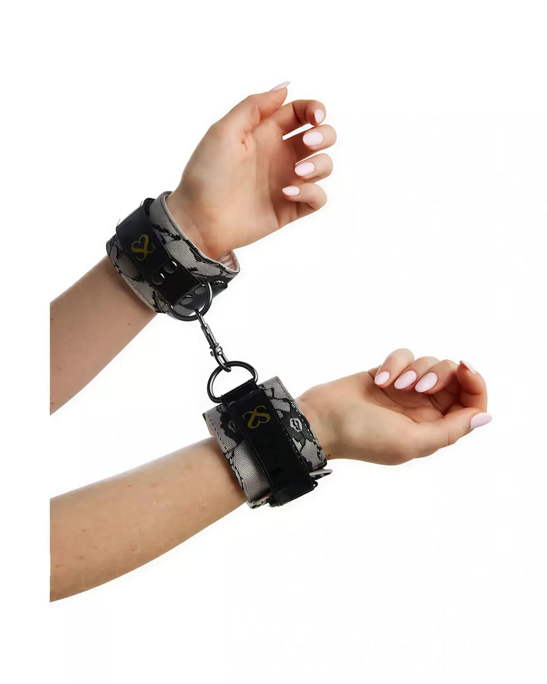 Luxury handcuffs with a snake print design, secured around wrists, featuring a metal chain connector.