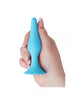 Medium silicone butt plug in blue held by a hand, featuring a tapered tip and flared base for safety.