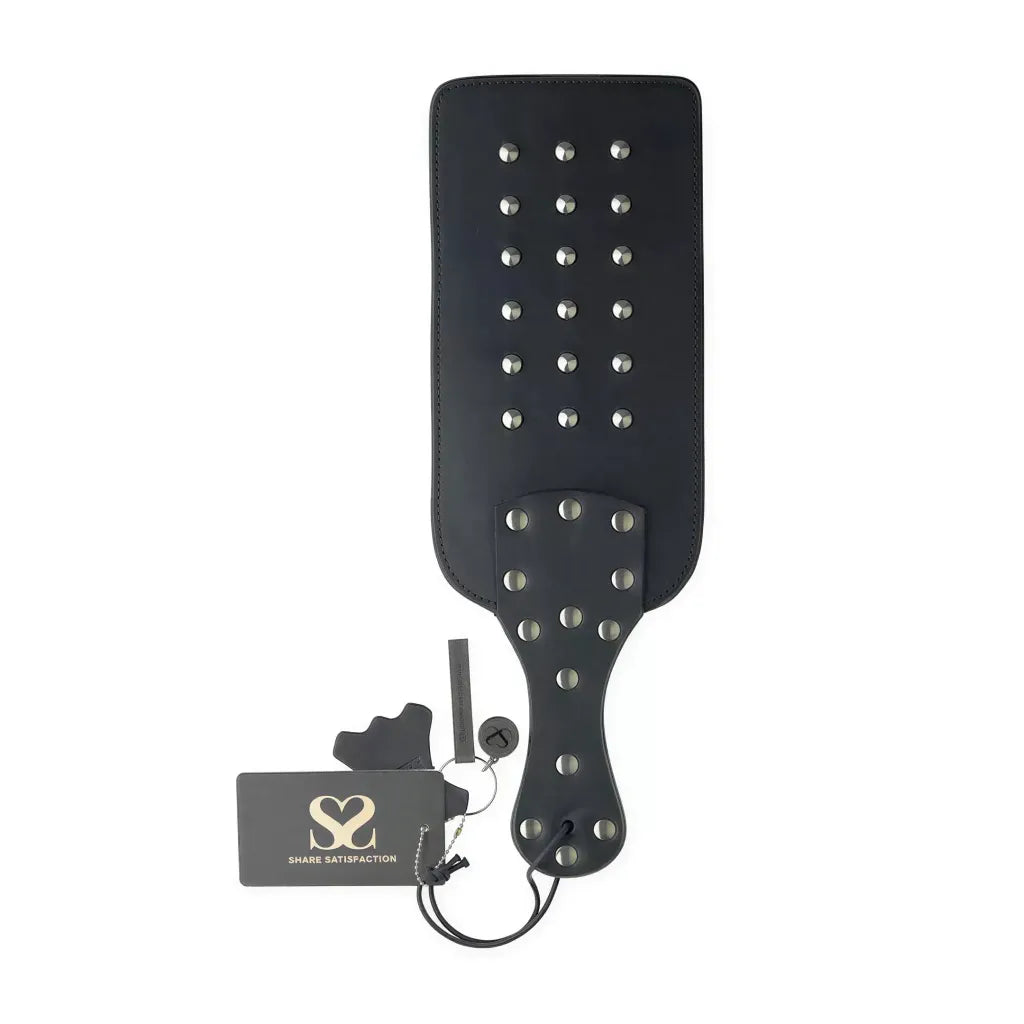 Share Satisfaction Bound X Wide studded paddle with a black leather surface and silver studs, featuring a hang tag.