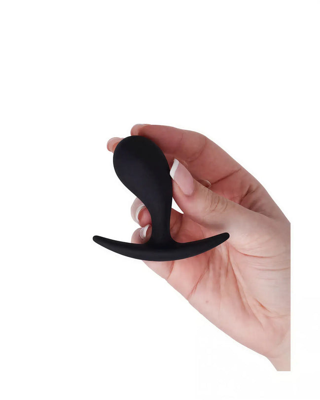 Medium curved plug held in a hand, featuring a smooth black silicone surface and a flared base for safety.