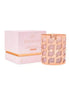 High On Love massage candle in a decorative pink holder next to its matching pink box.