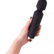Black silicone wand with a rounded head and metallic base, held in a hand.