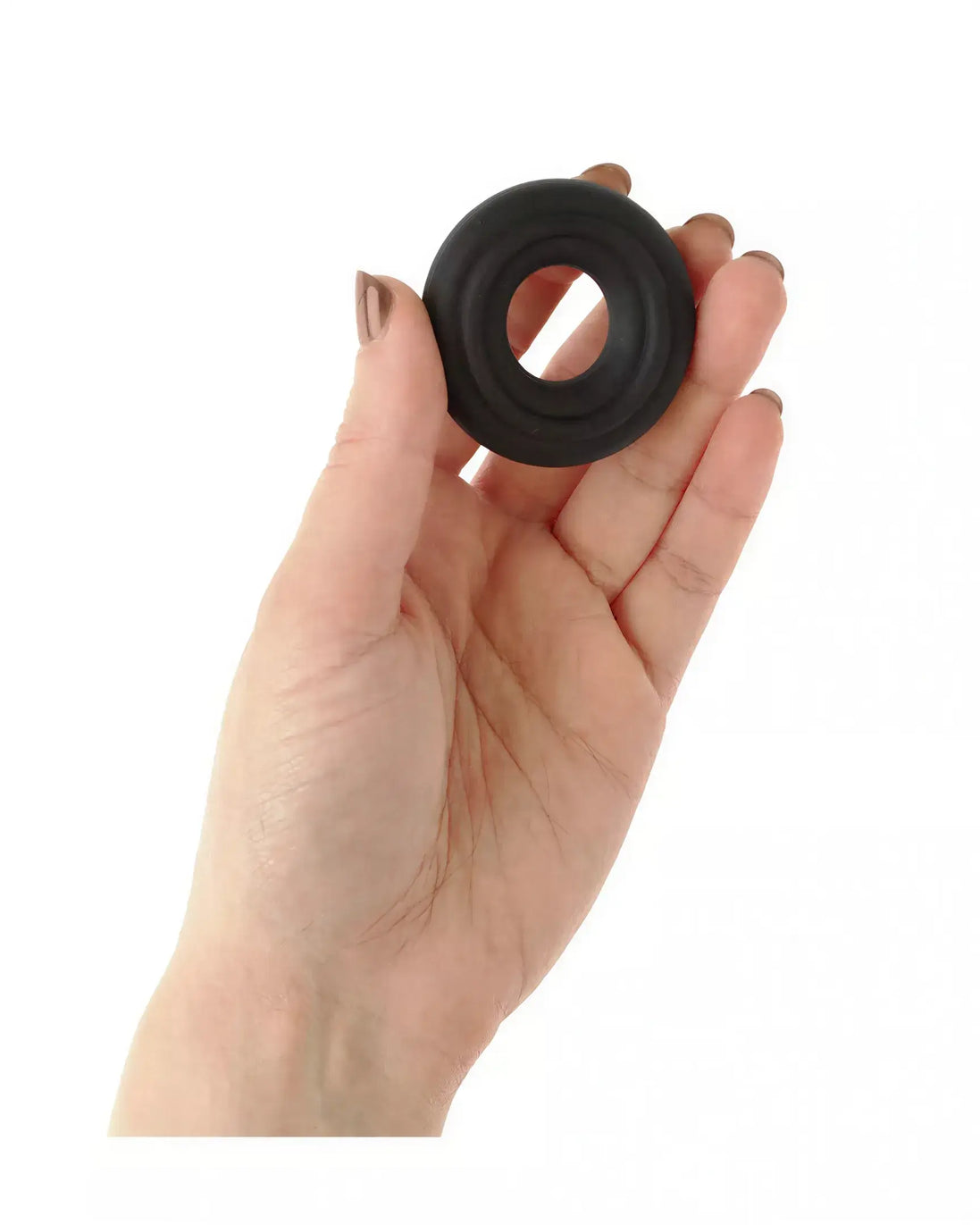 Black butter cookie cock ring held in a hand, showcasing its circular shape and textured surface.