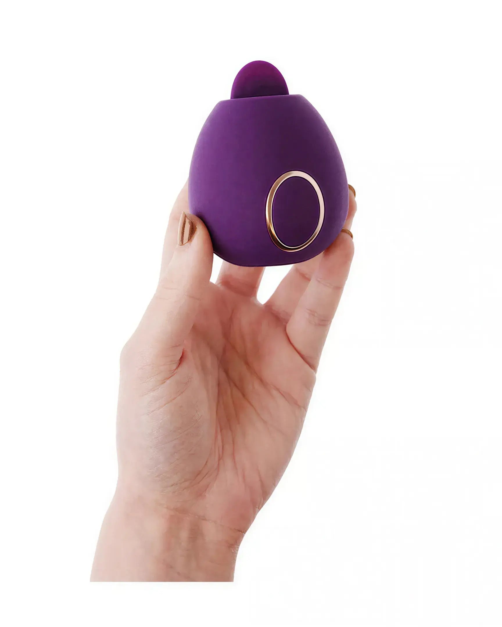 Purple Dana clitoral stimulator held in a hand, featuring a rounded shape and a gold accent button.