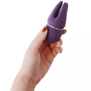 Purple Share Satisfaction Candi clitoral vibrator held in a hand, featuring a sleek design and gold accent.