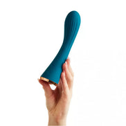 Teal silicone vibrator held in a hand, featuring a curved design and gold base accents.