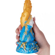Kinki Cthulhu tentacle dildo in blue and orange, featuring textured details and a hand holding it for scale.