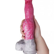 Kinki Canine Monster Dildo in pink and gray, held in a hand, featuring a textured design and a sturdy base.
