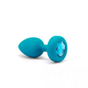 B-Vibe vibrating jewel plug in turquoise silicone with a blue gem accent, showcasing a tapered design.