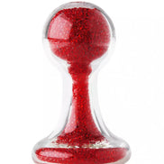 Lucent glass butt plug with a clear body and red glittery interior, featuring a rounded top and flared base.