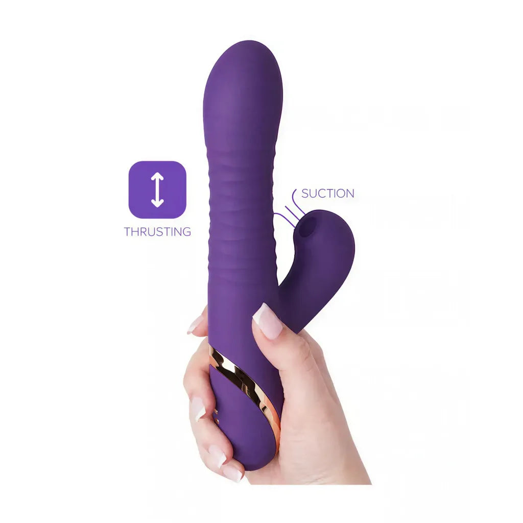 Purple thrusting suction vibrator held in a hand, featuring ridges and a curved design for targeted stimulation.