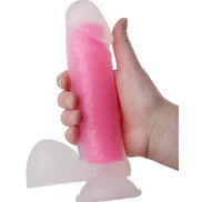 Nood Colours glow in the dark dildo, 8.1 inches long, held in a hand, featuring a pink translucent design.