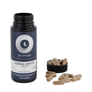 Herbal Ignite Him capsules in a black bottle with a white label, alongside several capsules on a white surface.