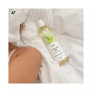 Satisfyer massage oil in lemongrass scent, 250ml bottle on a white fabric background.